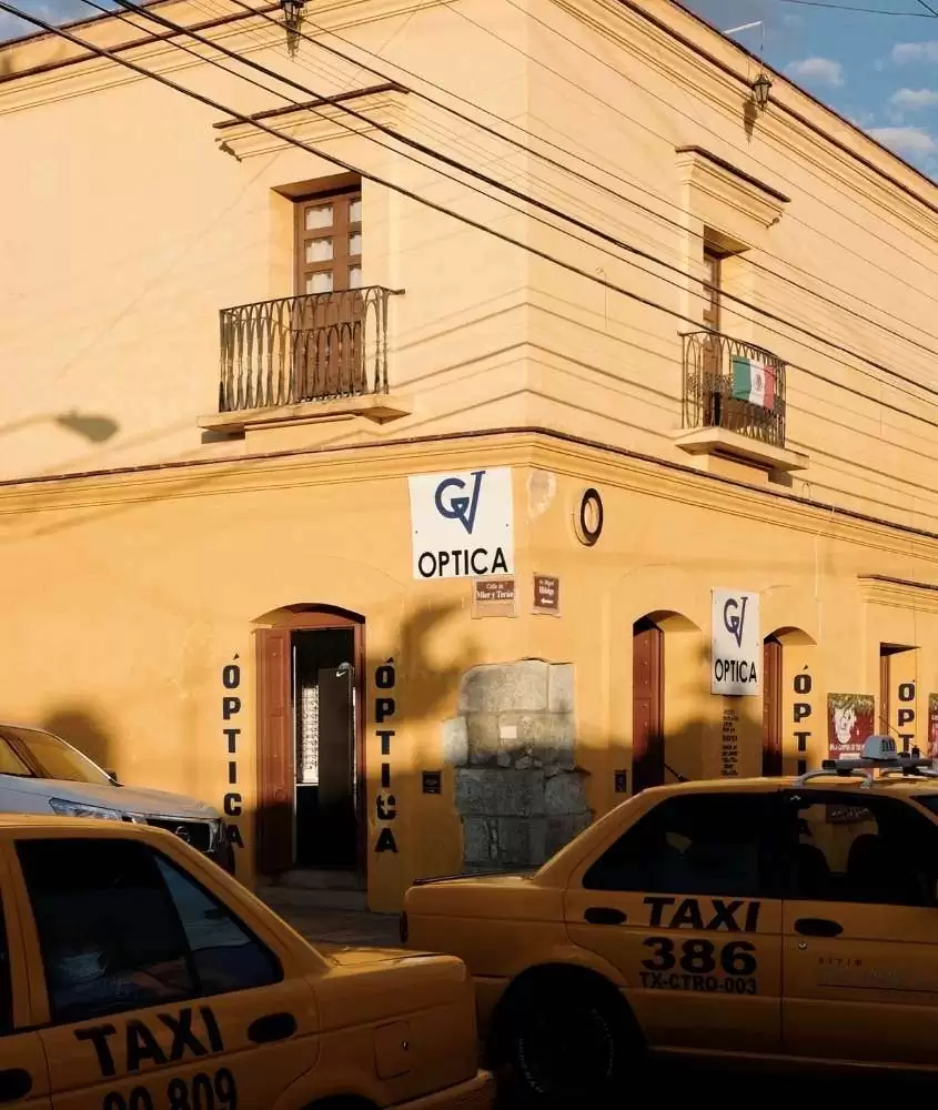 durante o dia, táxis amarelos em frente a construção amarela em ruas do méxico