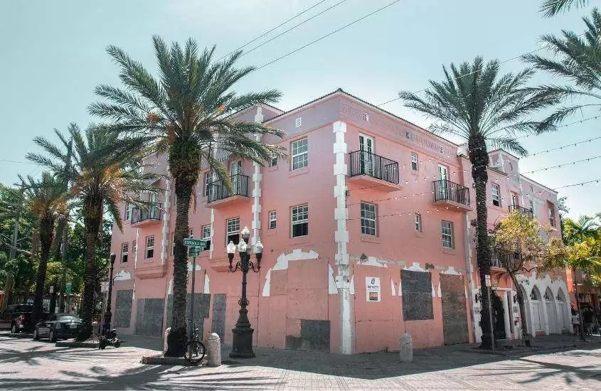 durante o dia, árvores ao redor de construção rosa de 3 andares em rua de Miami Estados Unidos