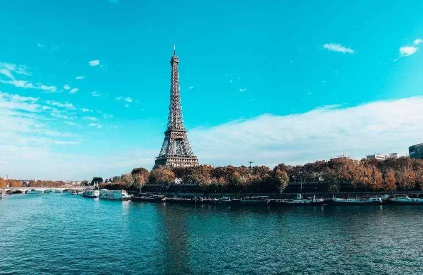 durante o dia, árvores e Torre Eiffel vistas de rio em paris, destino para o roteiro na frança
