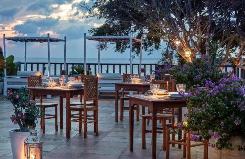 durante entardecer, cadeiras e mesas em restaurante ao ar livre com vista para o mar em um dos hotéis para passar o réveillon em Jericoacoara