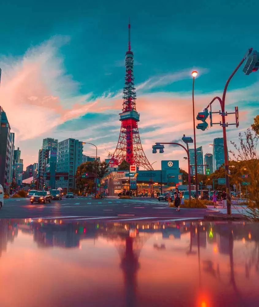 durante entardecer, prédios ao redor de estrutura vermelha com 333 metros de altura que é um dos pontos turísticos de Tokyo