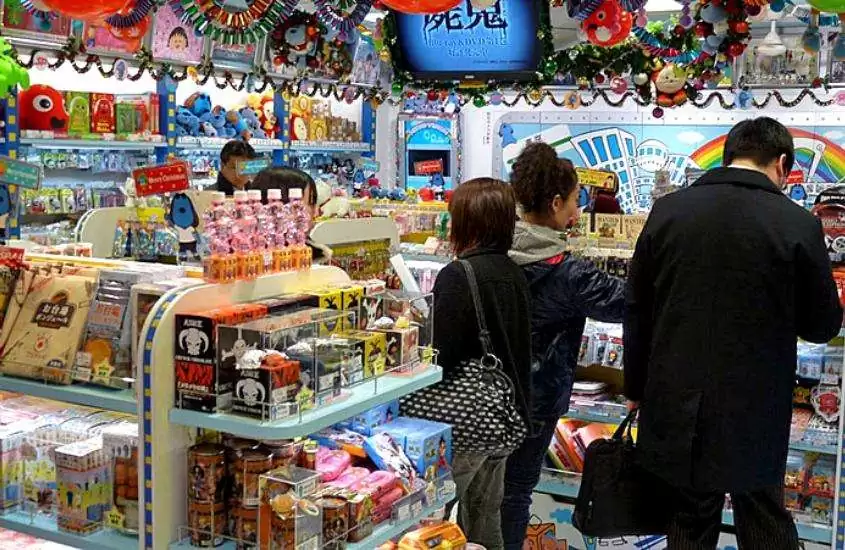 pessoas observando prateleira cheia de itens coloridos em uma das lojas de tokyo japão