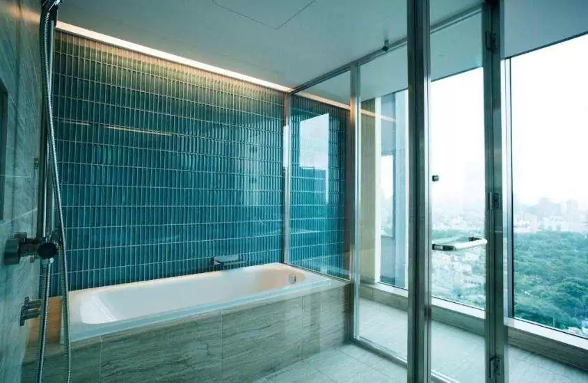 banheira de hidromassagem em banheiro com ampla janela com vista para a cidade