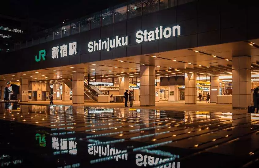 pessoas caminhando em estação de trem para fazer passeios em tokyo