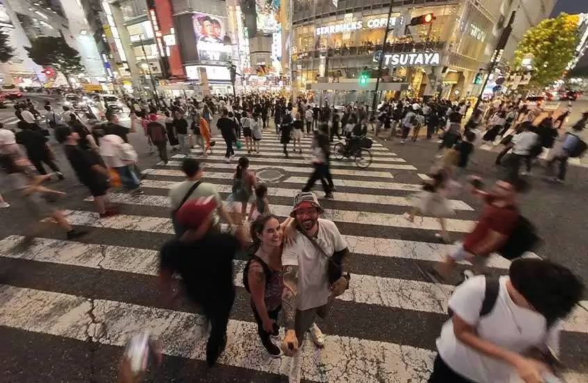 durante a noite, pessoas atravessando o cruzamento de Shibuya