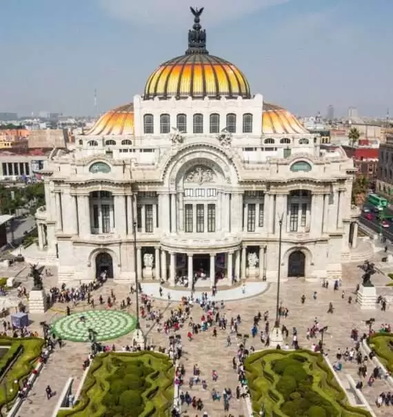 durante o dia, vista aérea de pessoas caminhando em grande praça chamada zocolo, um dos pontos turísticos da cidade do méxico