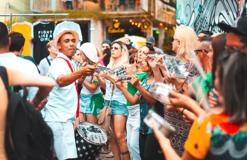 durante o dia, pessoas tocando instrumentos musicais e dançando em bloco de carnaval em florianópolis