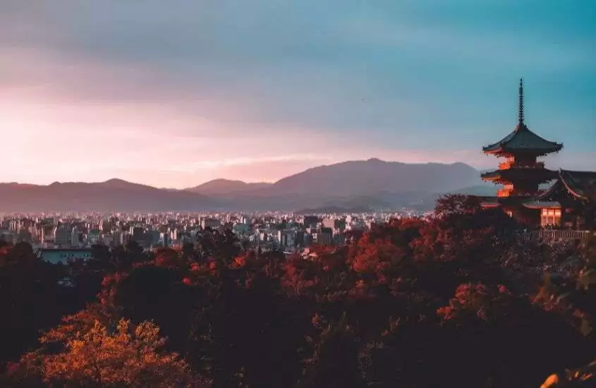 durante entardecer, vista aérea de árvores, prédios e montanhas no japão
