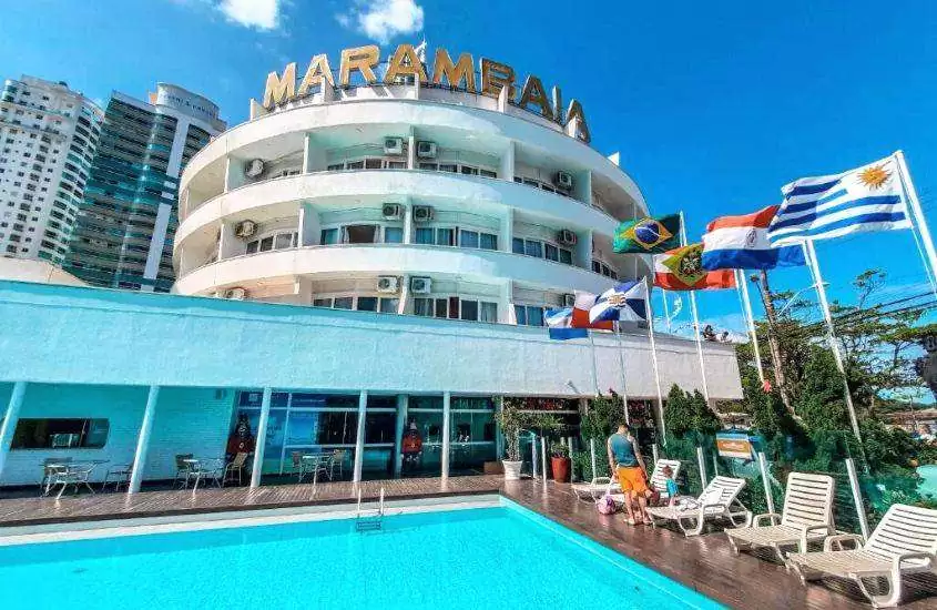 durante o dia, espreguiçadeiras ao redor de piscina ao ar livre em hotel onde passar o réveillon balneário camboriú 2023