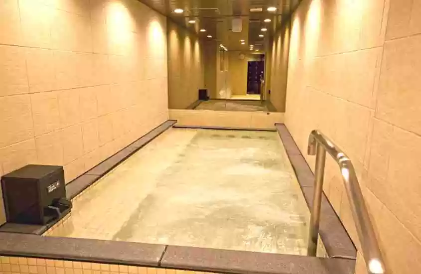 banheira de hidromassagem em frente a espelho em área de lazer coberta de um hotel cápsula em tokyo