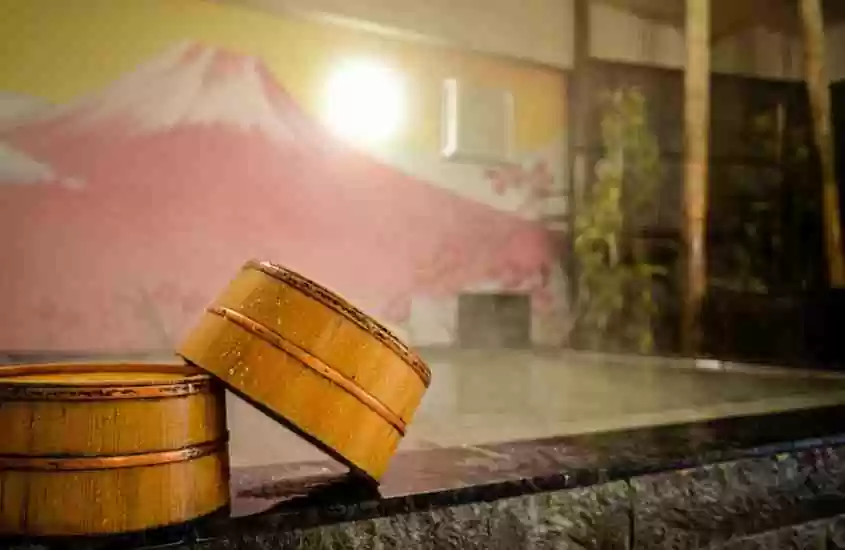 banheira de hidromassagem e pintura de monte fuji em parede de área de lazer coberta de hotel cápsula