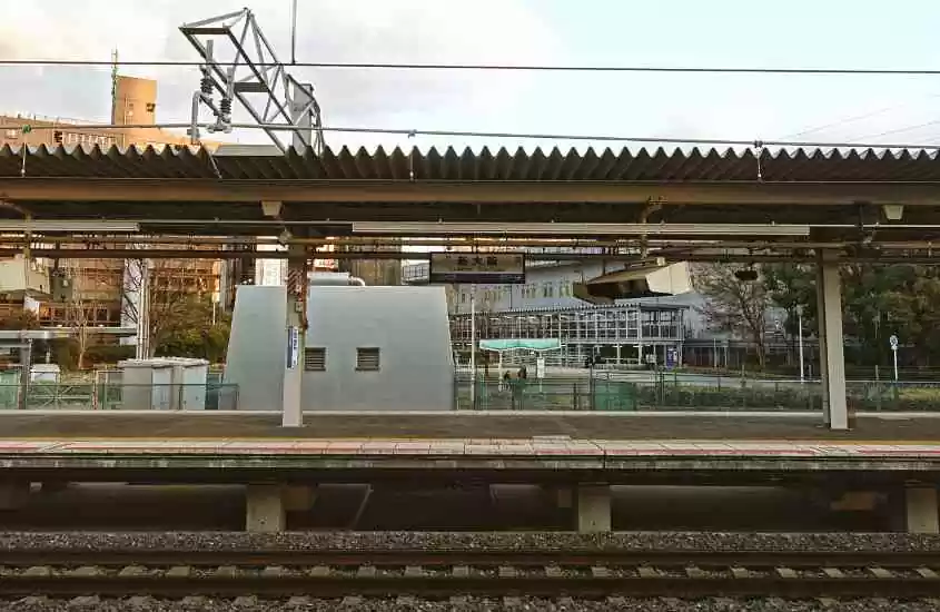durante o dia, plataforma em frente a trilhos em estação de trem