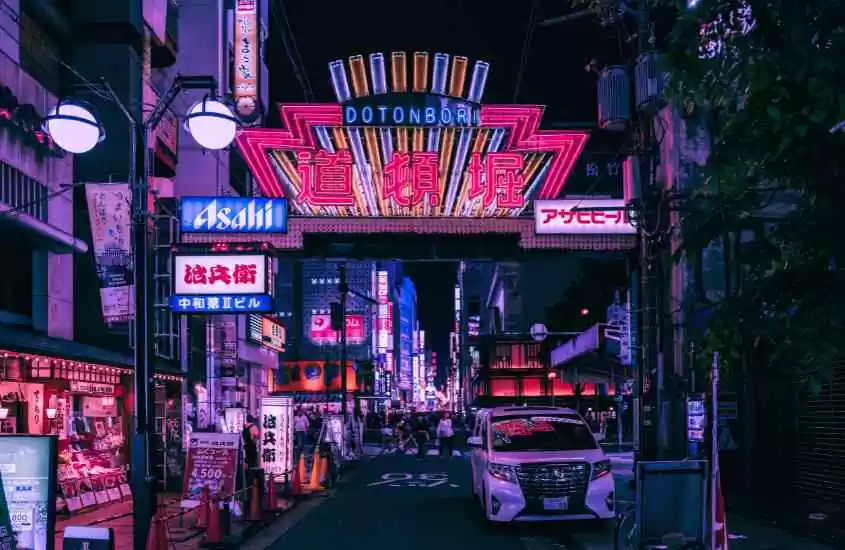 durante a noite, pessoas caminhando por ruas iluminadas de dotonbori, lugar para lista de o que fazer em Osaka a noite