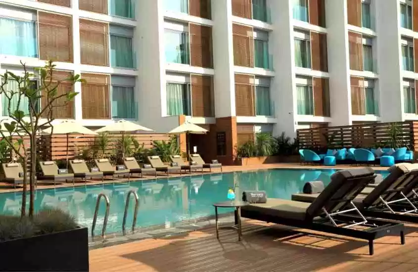 durante dia ensolarado, espreguiçadeiras e guarda-sóis ao redor de piscina retangular ao ar livre em um dos hotéis em casablanca