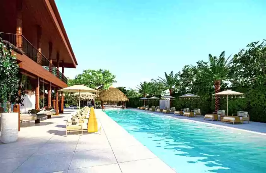 durante dia ensolarado, cadeiras e espreguiçadeiras em frente a grande piscina ao ar livre de um dos hotéis em koh samui