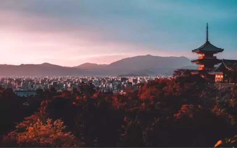 durante entardecer, vista aérea de árvores, templo, prédios e montanhas em kyoto japão