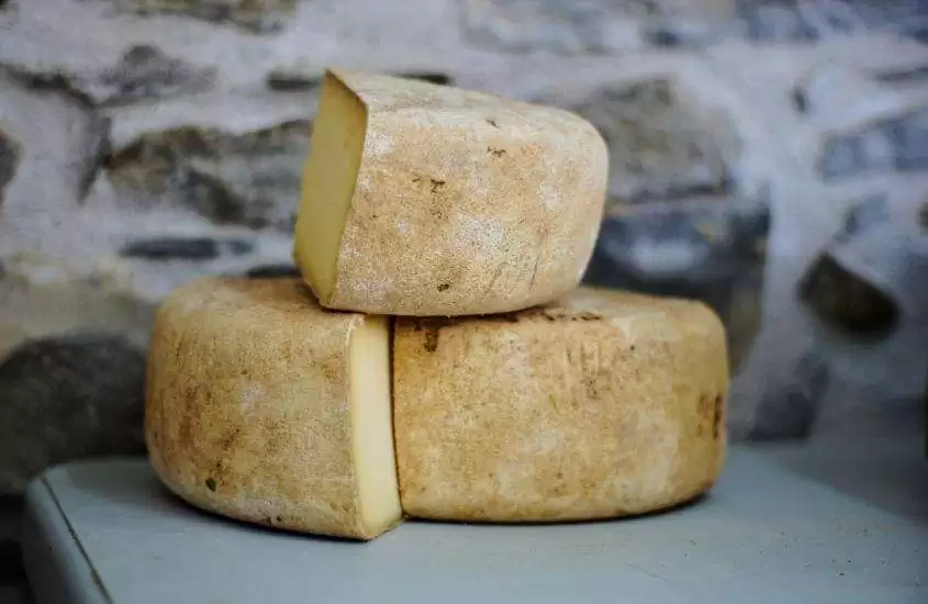 pedaços de queijo espanhol, dispostos em cima de uma mesa branca