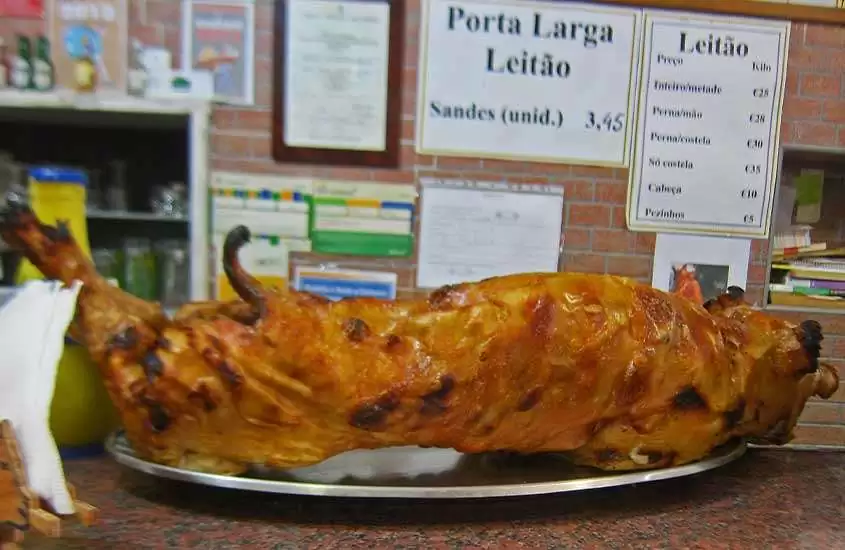Leitão da Bairrada, especialidade da culinária portuguesa, servido em assadeira de alumínio, sobre o balcão de um restaurante