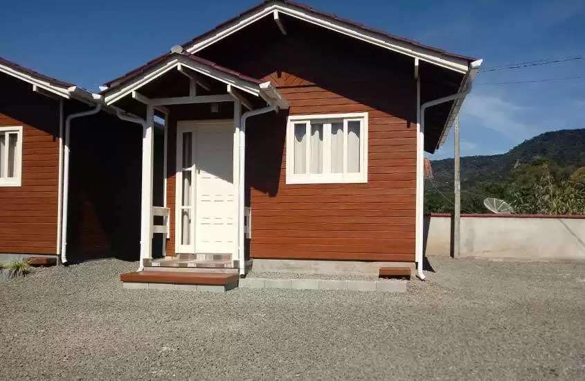 durante dia ensolarado, chalé de madeira, com portas e janelas brancas, em Urubici SC