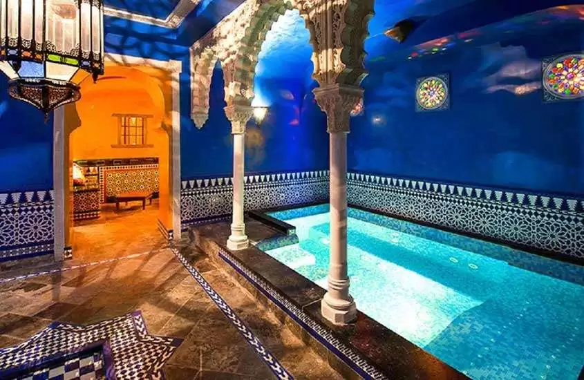 piscina retangular em área de lazer coberta com decoração temática que remete às Mil e Uma Noites
