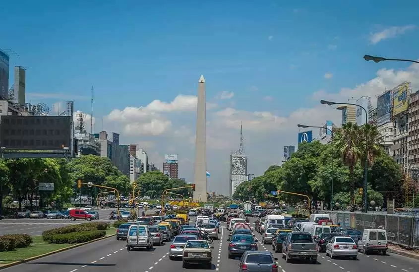 Durante o dia, vista aérea de trânsito congestionado em avenida movimentada com o icônico obelisco de Buenos Aires ao fundo