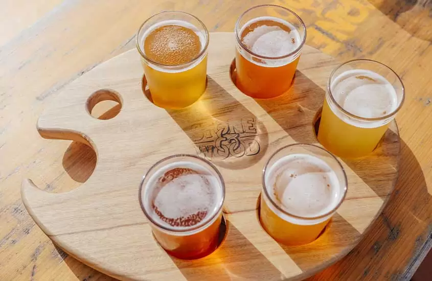 Vários copos de cervejas artesanais dispostos em uma mesa de madeira em uma das cervejarias em Bariloche
