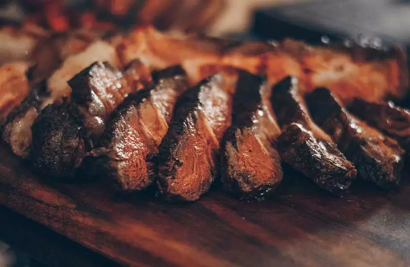 pedaços de carne mal passada em cima de tabua de madeira em um dos melhores restaurantes em bariloche