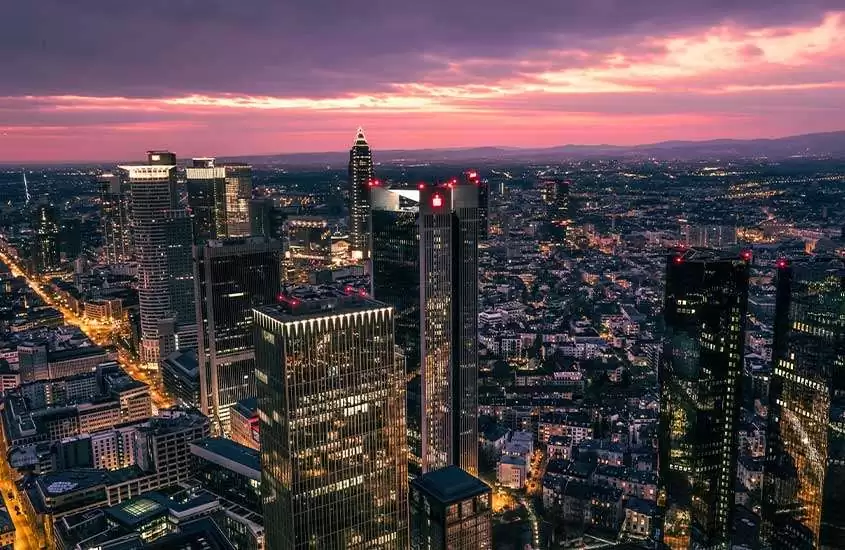 durante entardecer, vista aérea de casas, prédios e arranha-céus em Frankfurt Alemanha