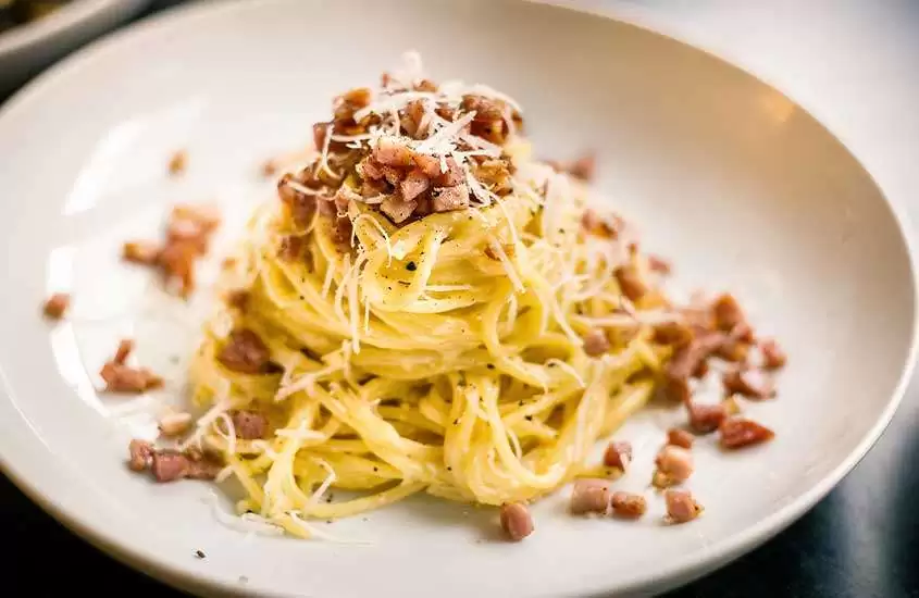macarrão com queijo pecorino, guanciale e pimenta-do-reino, uma comida típica da itália, servida em prato redondo