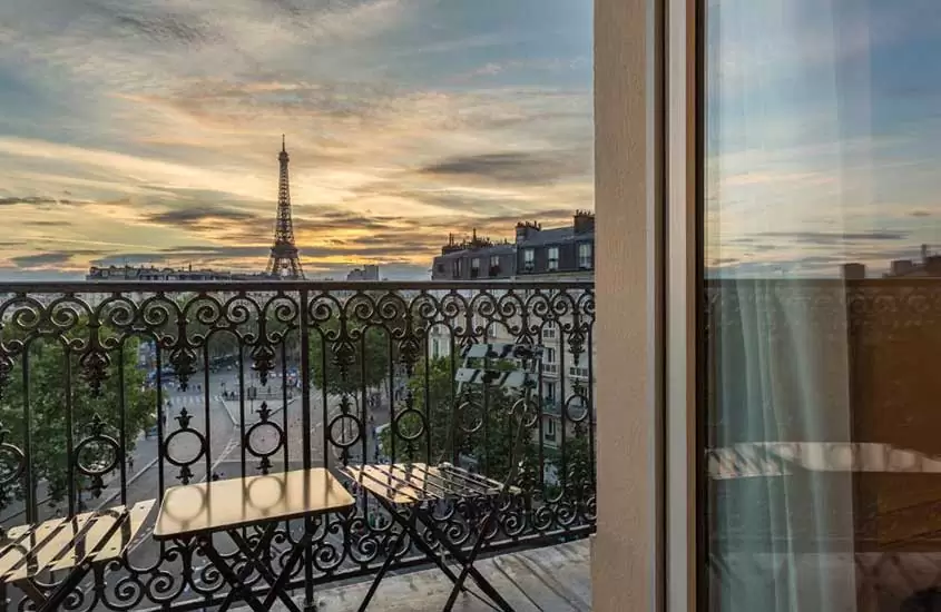 durante um entardecer, cadeiras e mesas em varanda de um dos melhores hotéis com vista para a Torre Eiffel