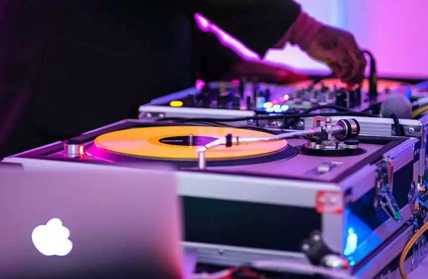 DJ mexendo em mesa de mixagem em beach club, uma das coisas legais para fazer em ibiza.