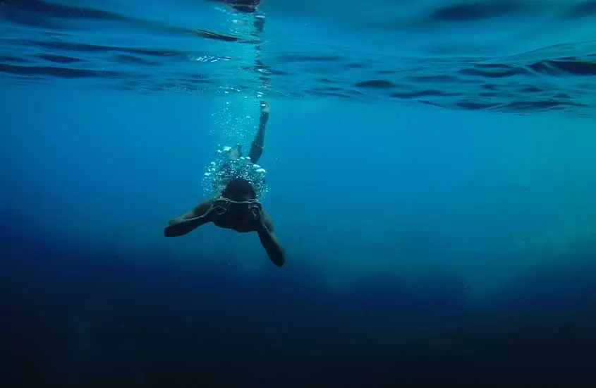 pessoa no fundo do mar, mergulhando com snorkel.