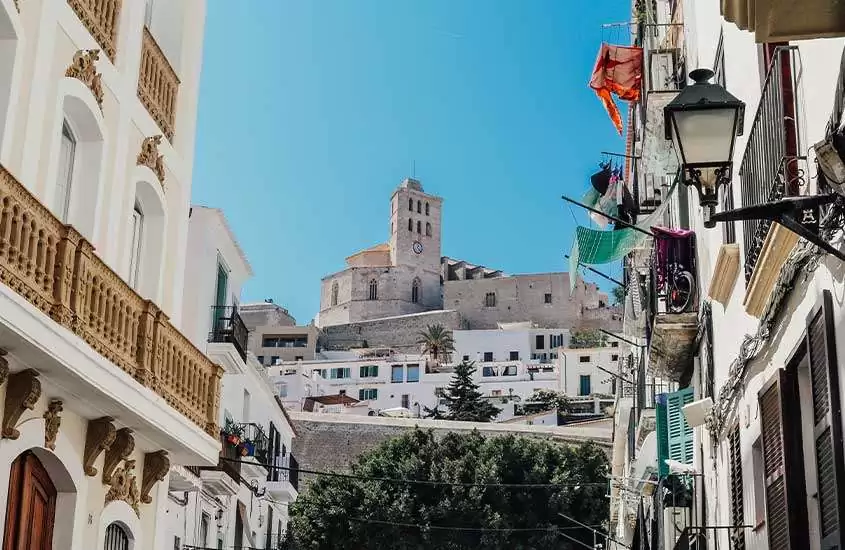 Durante um dia ensolarado prédios históricos em Dalt Vila, bairro que é uma das atrações para quem busca o que fazer em Ibiza.