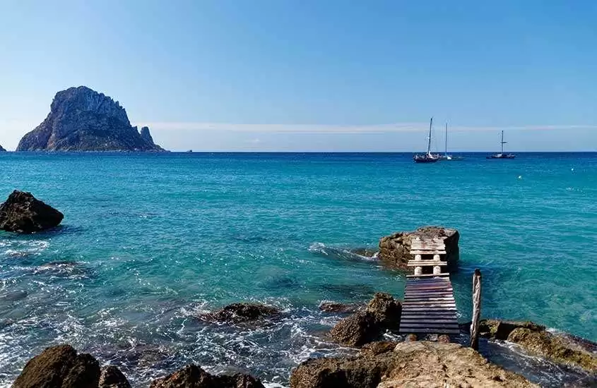 durante um dia ensolarado, ponte de madeira sobre o mar em uma das praias em Ibiza.