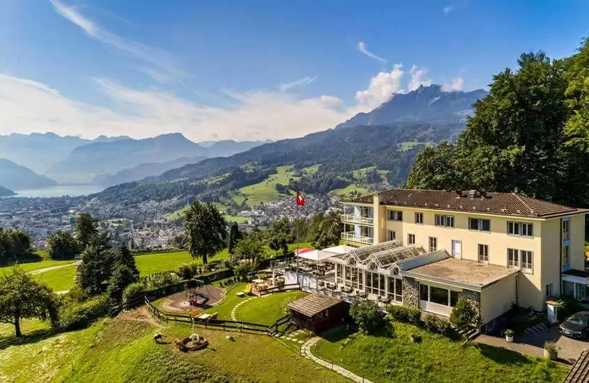 durante um dia ensolarado, vista aérea de casas em topo de montanha com vista para um lago em Lucerna Suíça.