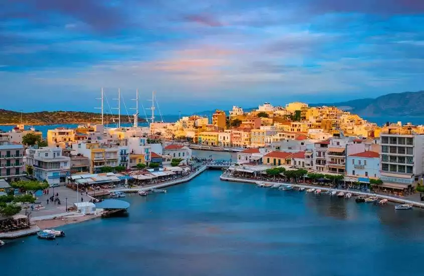 Durante o entardecer, vista panorâmica de construções coloridas às margens do mar em Creta, um dos melhores destinos na grecia