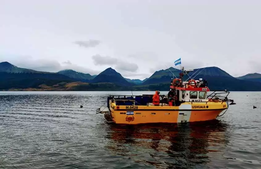 durante um dia nublado, barco amarelo de pesca em mar, rodeado por montanhas