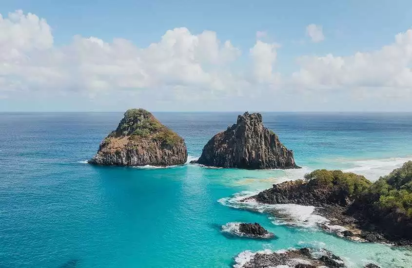 Em dia ensolarado com algumas nuvens, vista aérea panorâmica de rochas ''dois irmãos'' no mar de Fernando de Noronha,