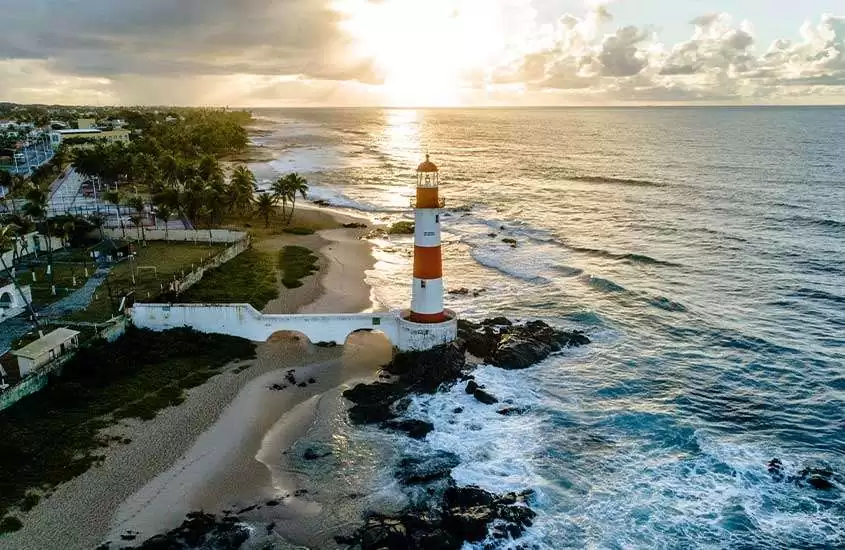 Em entardecer com nuvens, vista aérea do farol de salvador às margens do mar.