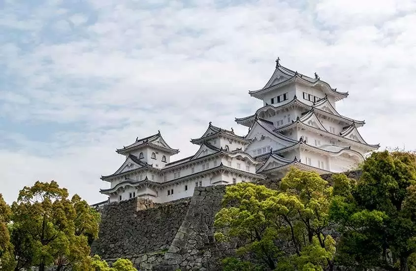 Em dia de sol, vista panorâmica de Castelo Himeki com árvores em volta