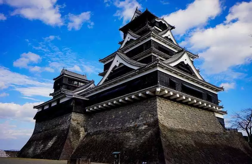 Durante um dia de sol com nuvens, castelo de Fukuoka em cima de estrutura de pedras