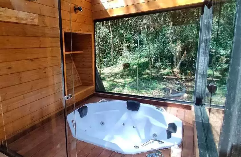 durante o dia, banheira em chalé romântico em santa catarina com janelas grandes e vista para a natureza