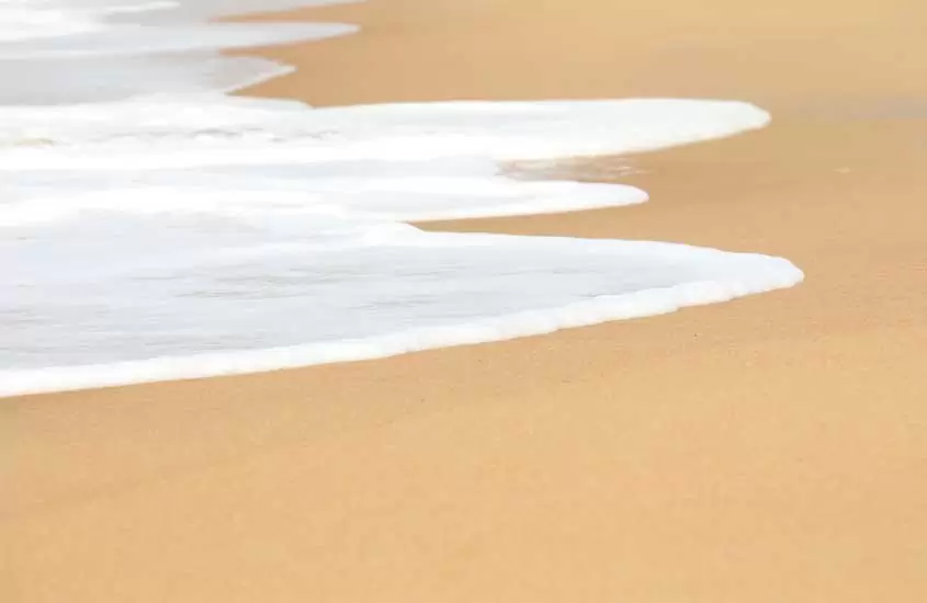 espuma de onda na areia da praia de itaúnas es