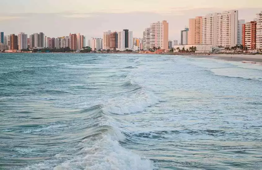 Durante o final de tarde, praia de São Luís, um dos lugares baratos para passar o ano novo com mar na frente e cidade no fundo