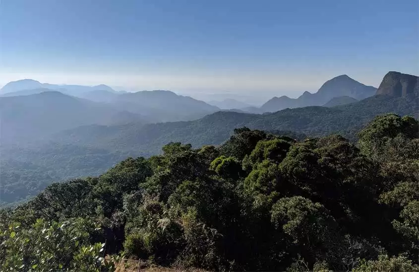 Em um dia de sol, horizonte com montanhas e árvores de um lugar barato para passar o ano novo