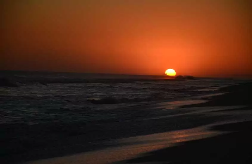 Durante o por do sol de Araruama, praia com o reflexo do sol na areia