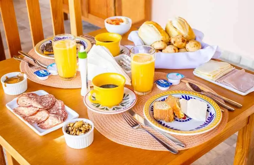 Mesa de café da manhã de Hotel Fazenda na Serra da Mantiqueira com sucos, cafés, bolos, pães, frios e castanhas