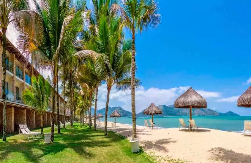 Em um dia de sol, praia privativa de resort com espreguiçadeiras, árvores e varanda de resort