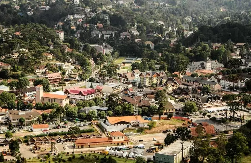 Em um dia de sol, vista aérea de Campos do Jordão, um dos lugares para passar o réveillon, com casas, árvores e ruas ao redor